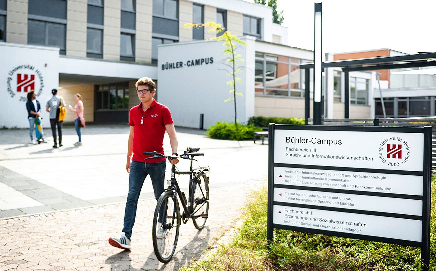 Student schiebt sein Fahrraf über den Bühler-Campus