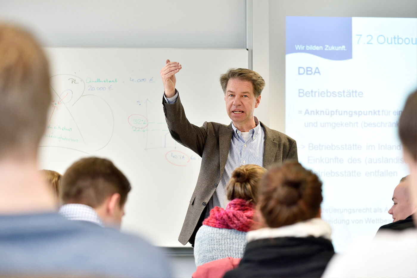 Lehrender mit Studierenden im Seminar an der HS Weserbergland 