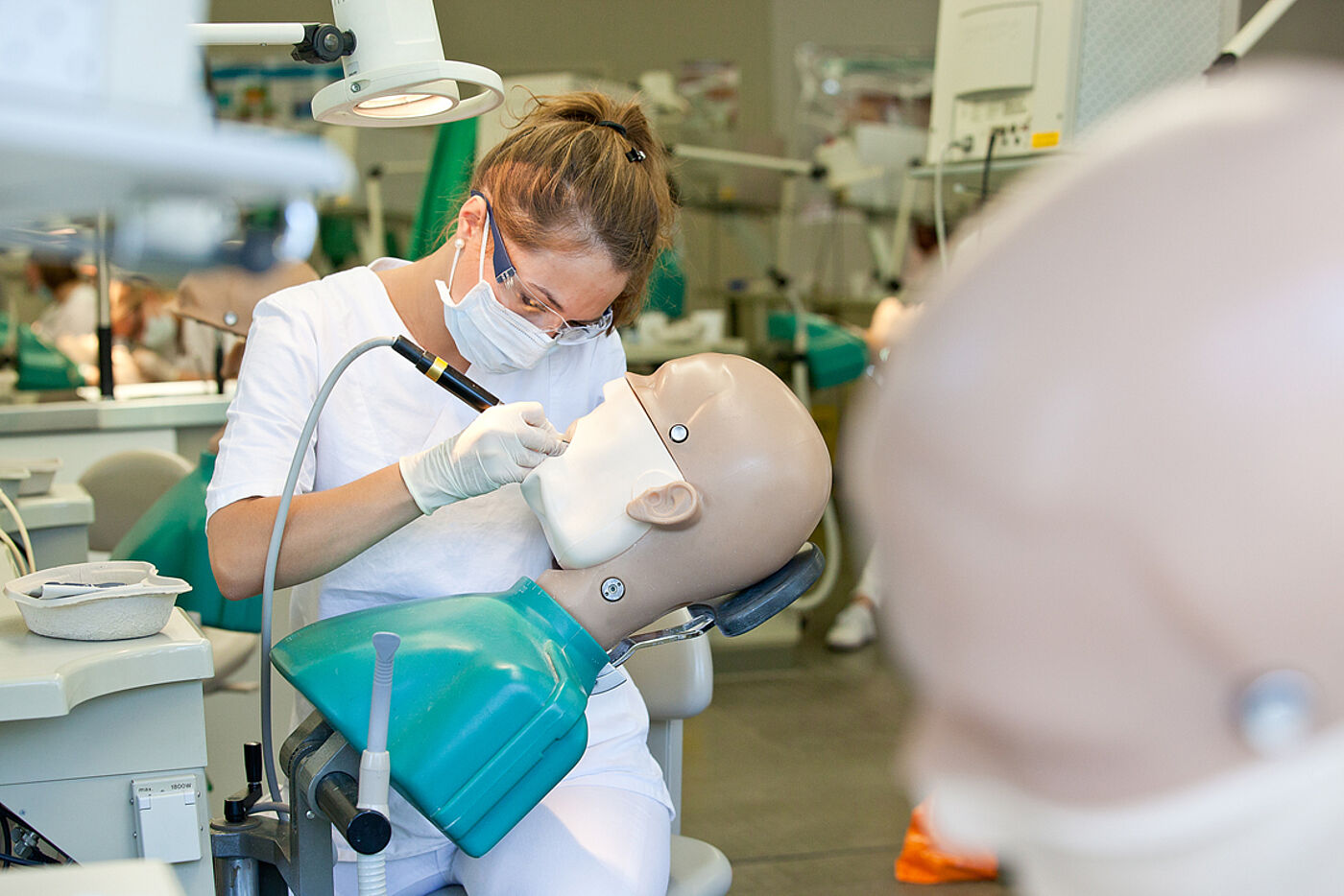 Studierende der Zahnmedizin an der MHH übt an einem Kiefer-Modell mit künstlichem Gebiss 