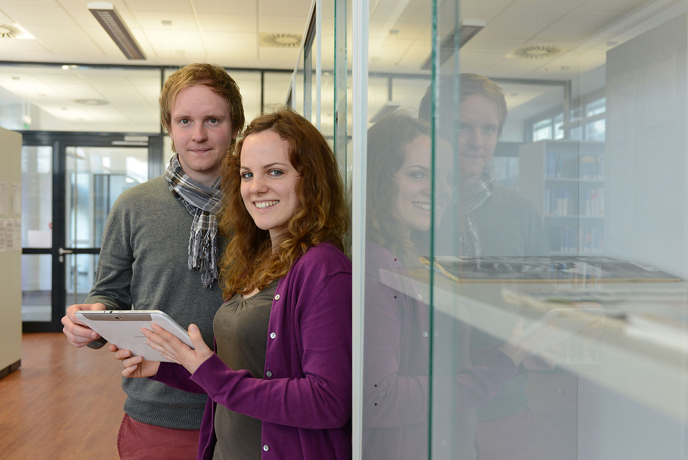 Zwei Studierende der Leibniz-FH betrachten etwas auf einem Tablet-PC 