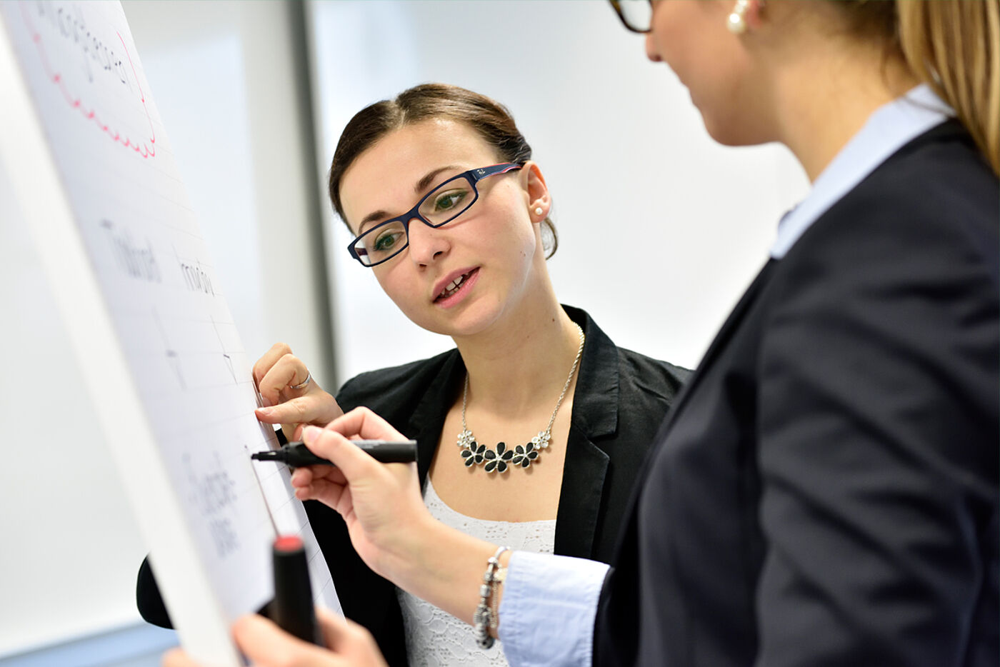 Zwei Studierende der HS Weserbergland arbeiten am Whiteboard zusammen