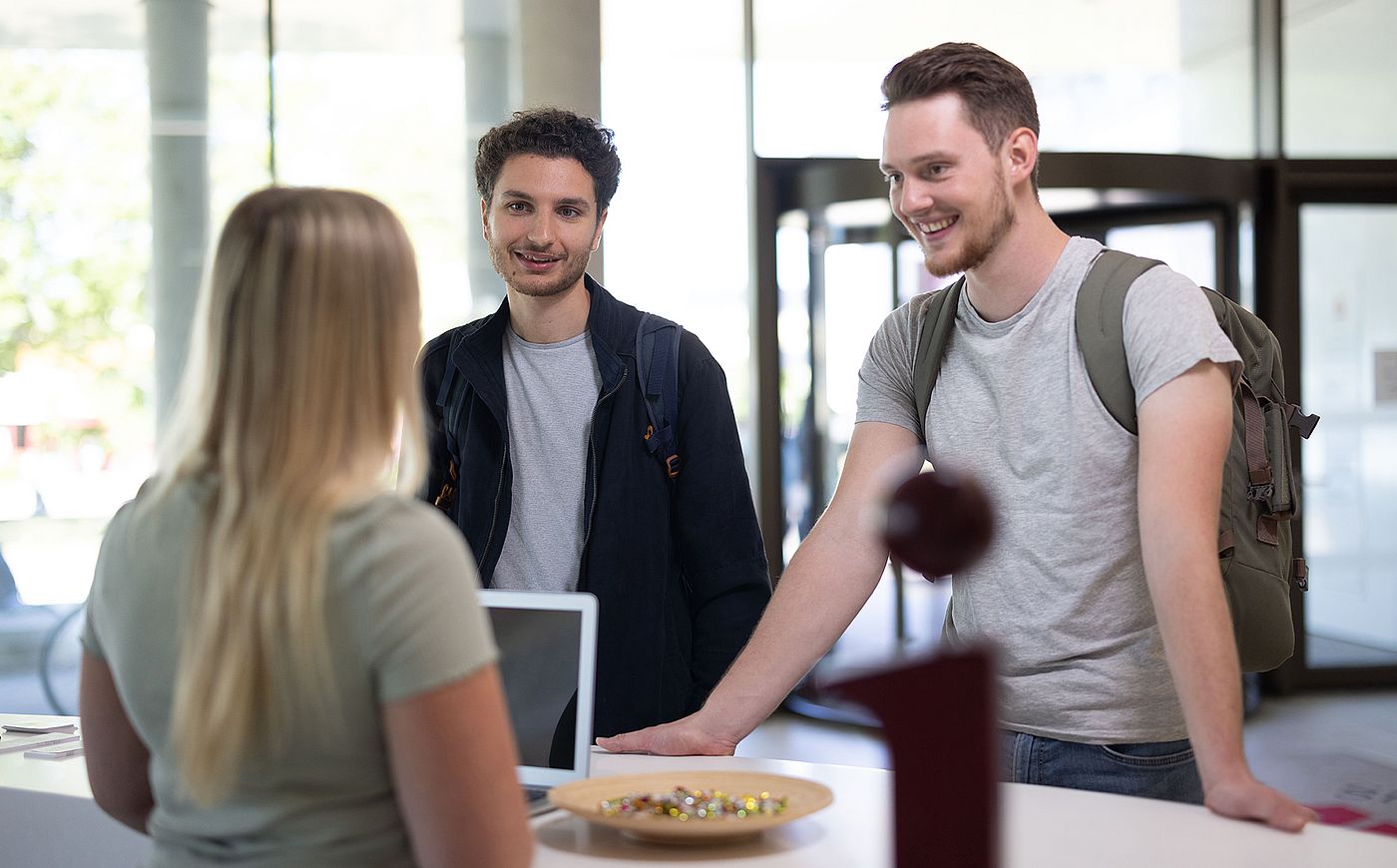 Studierende stehen am Infodesk im Forum am Hauptcampus