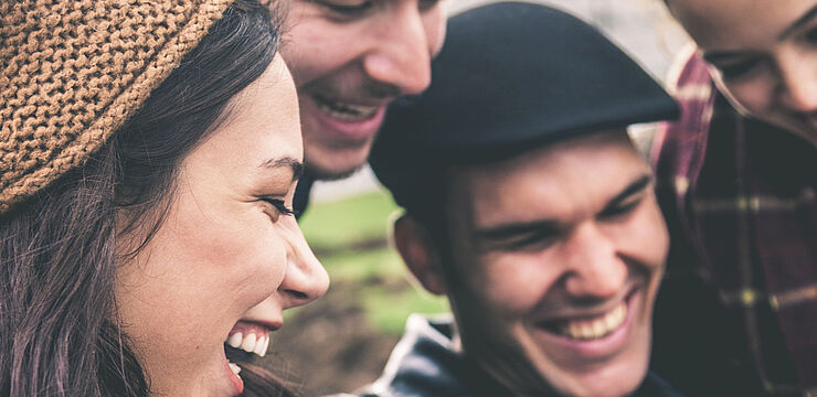 Junge Menschen zeigen einander etwas auf einem Smartphone