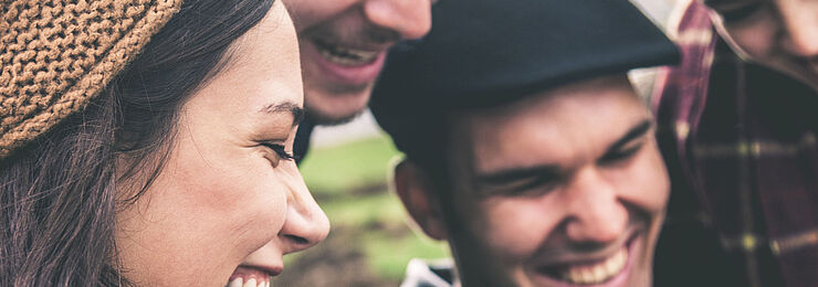 Junge Menschen zeigen einander etwas auf einem Smartphone