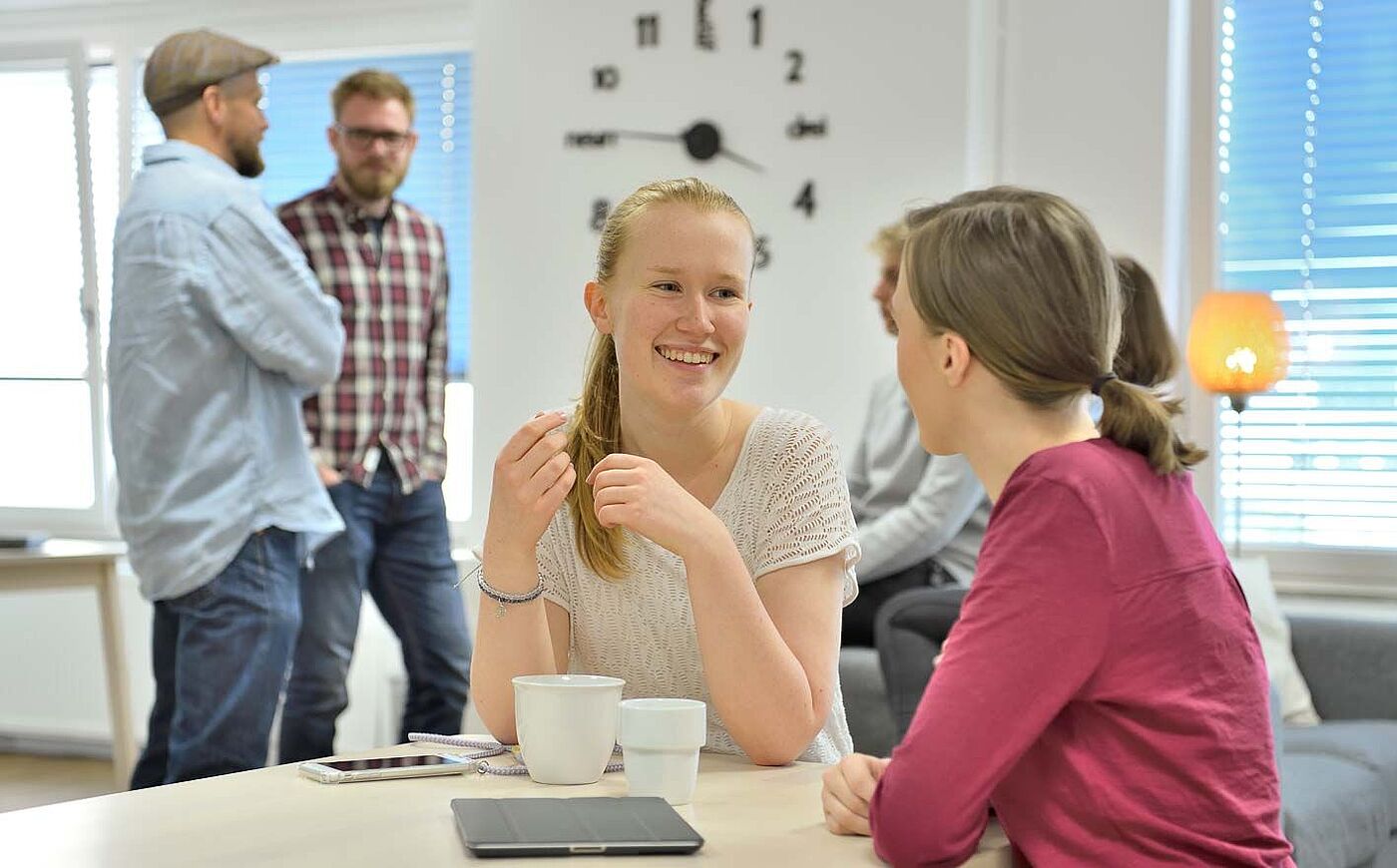 Studierende der HS Weserbergland sitzen an studentischen Arbeitsplätzen zusammen