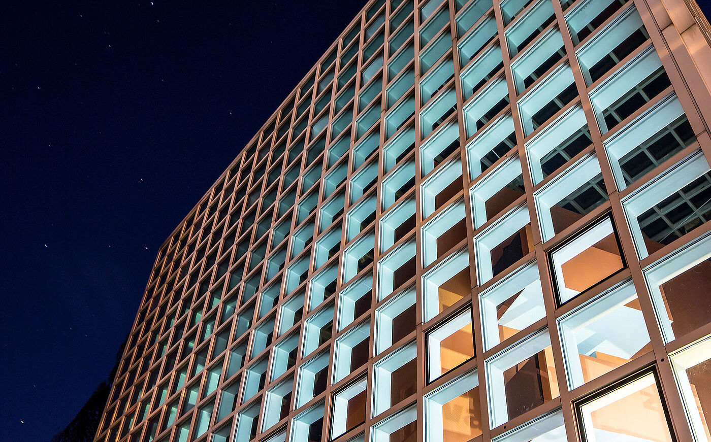 Beleuchtetes Hochschulgebäude der HBK Braunschweig bei Nacht